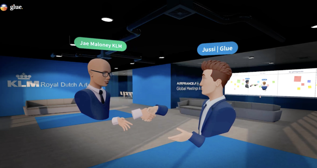 Jae Maloney from KLM and Jussi from Glue shaking hands in a persistent collaborative workspace, showing an alternative to Microsoft Mesh for branded meetings.
